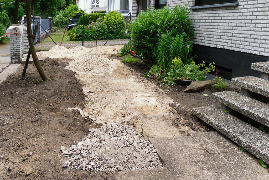 Umgestaltung des Vorgarten eines Einfamilienhauses: Neuer Untergrund für die gepflasterten Flächen